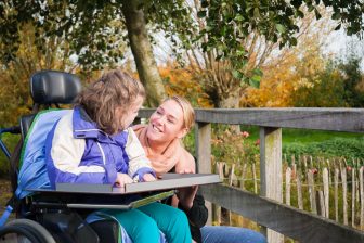 47991012 - disabled child in a wheelchair outside with care assistant